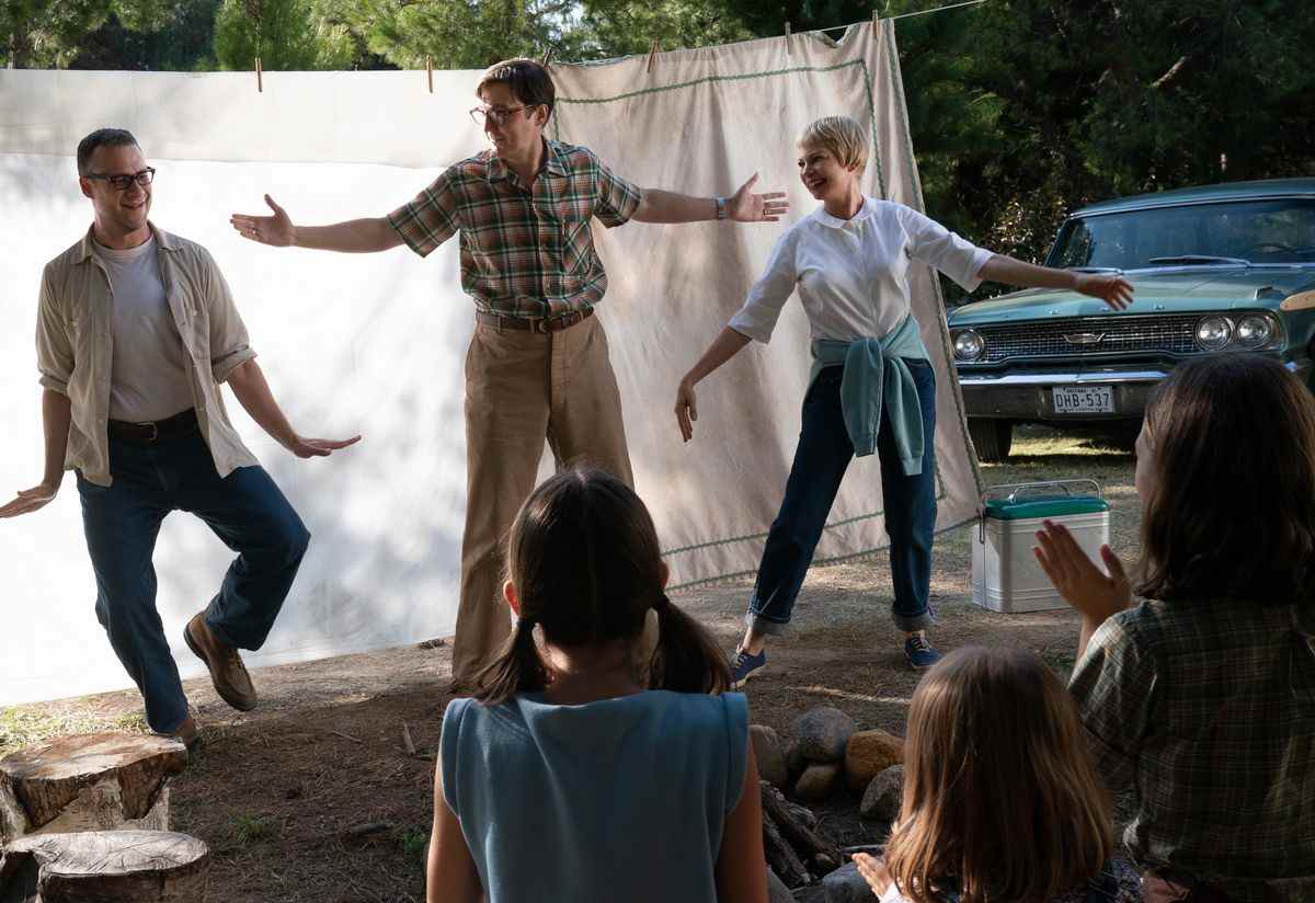 Bennie Loewy (Seth Rogen), Burt Fabelman (Paul Dano) et Mitzi Fabelman (Michelle Williams), gambadent devant un drap de lit suspendu blanc tandis que plusieurs personnes tournent le dos à la caméra dans The Fabelmans