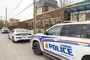 Plusieurs voitures de police de Londres sont garées devant l'école secondaire HB Beal au centre-ville de Londres après qu'une étudiante a été poignardée dans la cafétéria le lundi 21 novembre 2022. (Mike Hensen/The London Free Press)