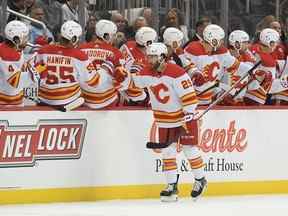 L'attaquant des Flames de Calgary Dillon Dube célèbre avec ses coéquipiers sur le banc après avoir marqué un but contre les Penguins de Pittsburgh au PPG Paints Arena de Pittsburgh le mercredi 23 novembre 2022.