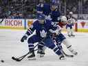 Le défenseur des Maple Leafs de Toronto Mac Hollowell (81) tente de contrôler la rondelle alors que l'attaquant Ilya Mikheyev (65) bloque l'attaquant des Canadiens de Montréal Mathieu Perreault (85) au cours de la deuxième période à la Scotiabank Arena. 