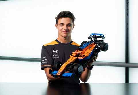 le pilote de formule 1 lando norris sourit alors qu'il tient la voiture lego technic mclaren f1, numéro d'identification du produit lego 42141