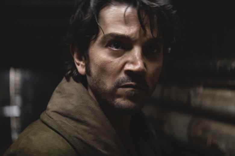 Shadowy close up on a man with dark hair, looking determined; still from "Andor."