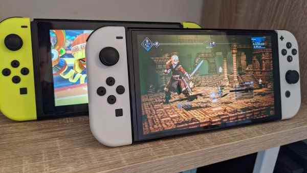 Deux consoles Nintendo Switch OLED sur un bureau