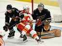 L'attaquant des Flames de Calgary Andrew Mangiapane affronte le défenseur des Capitals de Washington Nick Jensen et le gardien de but Darcy Kuemper au Capital One Arena de Washington le vendredi 25 novembre 2022.