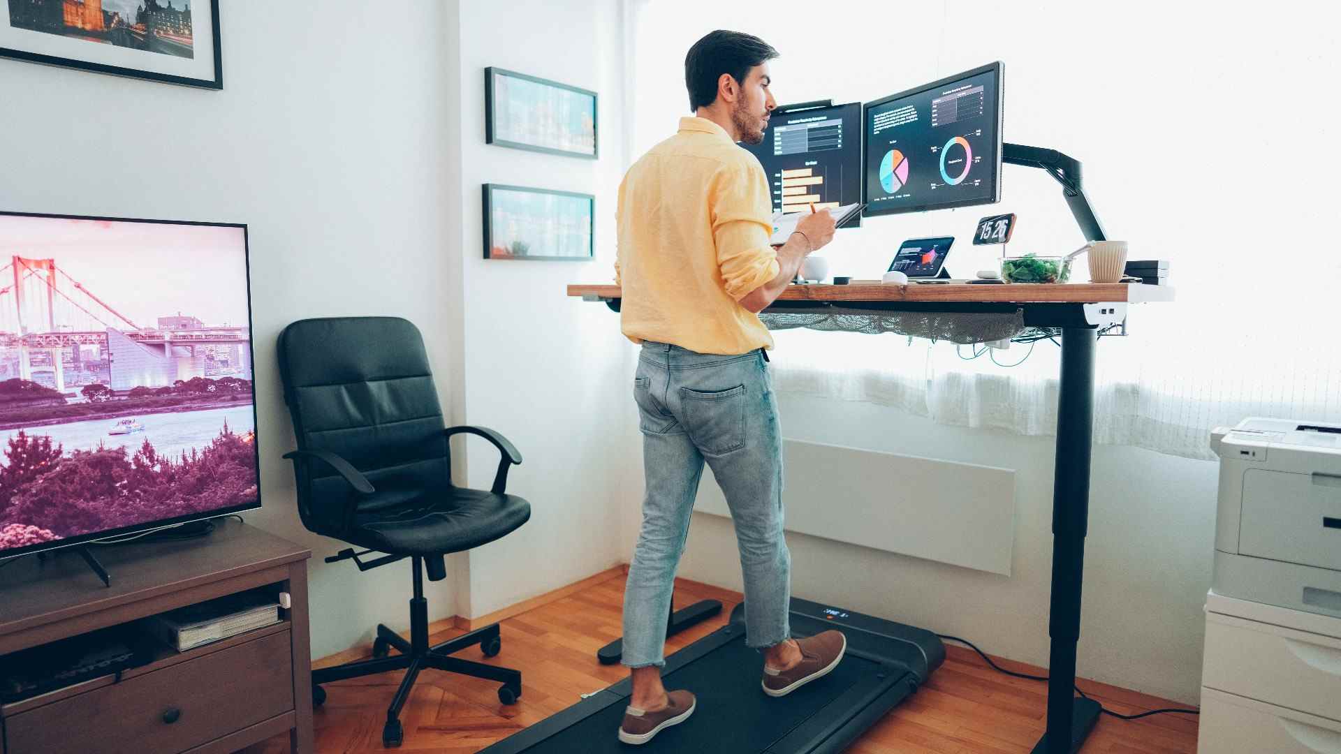 Homme marchant sur un tapis roulant sous le bureau à la maison