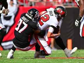 Est-ce un marché baissier face à Tom Brady ?  Non, son Grady Jarrett # 97 des Falcons d'Atlanta limoge Tom Brady # 12 des Buccaneers de Tampa Bay au cours du quatrième quart du match au Raymond James Stadium le 9 octobre 2022 à Tampa, en Floride.