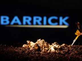 Une petite figurine et une imitation d'or sont visibles devant le logo Barrick dans cette illustration prise le 19 novembre 2021.