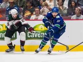 Bo Horvat des Canucks de Vancouver (à droite) contourne le défenseur des Coyotes de l'Arizona Conor Timmins lors d'un match à Vancouver le 7 octobre 2022. Les Maple Leafs ont acquis Timmins mercredi.