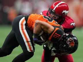 Bryan Burnham, des Lions de la Colombie-Britannique, à l'avant, est plaqué par Brad Muhammad des Stampeders de Calgary lors de la première moitié du match de football de la LCF à Vancouver, le samedi 24 septembre 2022.