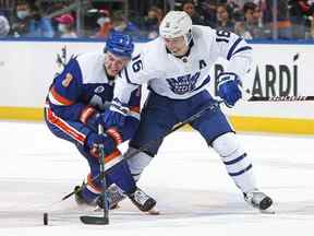 Mitchell Marner des Maple Leafs de Toronto tente d'empêcher Adam Pelech des Islanders de New York de prendre possession de la rondelle au cours de la troisième période à l'UBS Arena le 22 janvier 2022 à Elmont, New York.  Les Maple Leafs ont vaincu les Islanders 3-1.