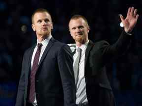 Henrik et Daniel Sedin ont leurs maillots retirés avant un match entre les Canucks de Vancouver et les Blackhawks de Chicago au Rogers Arena de Vancouver, le 12 février 2020.