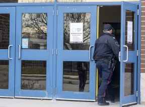 Un policier de Londres entre à l'école secondaire HB Beal sur Dundas Street à Londres après qu'une étudiante a été poignardée à la cafétéria au déjeuner le lundi 21 novembre 2022. (Mike Hensen/The London Free Press)