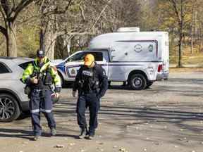 Un officier de police de Londres et un membre de Search and Rescue London fouillent le parking à l'entrée de Grosvenor Street à Gibbons Park le lundi 7 novembre 2022. Un homme a été retrouvé insensible dimanche et est décédé plus tard dans ce que la police appelle un homicide .  (Mike Hensen/The London Free Press)