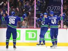 L'attaquant des Canucks de Vancouver Ilya Mikheyev célèbre son but contre les Predators de Nashville avec l'attaquant Elias Pettersson et l'attaquant Andrei Kuzmenko lors de la première période au Rogers Arena.