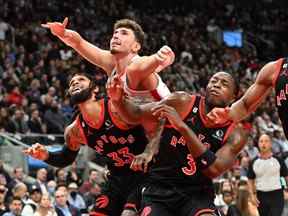 Alperen Sengun (au centre) des Houston Rockets se bat pour la position avec Gary Trent Jr. des Raptors et OG Anunoby en première mi-temps à la Scotiabank Arena le mercredi 9 novembre 2022.