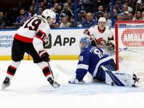 Tim Stutzle (18 ans) des Sénateurs d'Ottawa passe la rondelle à Drake Batherson, qui est arrêté par le gardien du Lightning de Tampa Bay Andrei Vasilevskiy en deuxième période à l'aréna Amalie mardi soir.