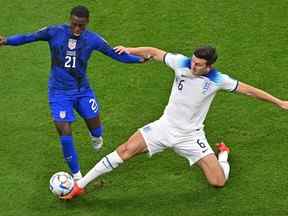 L'attaquant américain #21 Timothy Weah (L) se bat pour le ballon avec le défenseur anglais #06 Harry Maguire lors du match de football du groupe B de la coupe du monde Qatar 2022 entre l'Angleterre et les États-Unis au stade Al-Bayt à Al Khor, au nord de Doha, vendredi.