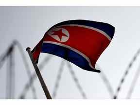 Le drapeau nord-coréen flotte sur fond de barbelés à l'ambassade de Corée du Nord à Kuala Lumpur.  Photographe : Manan Vatsyayana/Getty Images