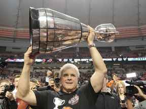 Wally Buono, directeur général et entraîneur principal des Lions de la Colombie-Britannique, soulève la Coupe Grey après avoir remporté la 99e Coupe Grey de la LCF au BC Place de Vancouver en novembre 2011.