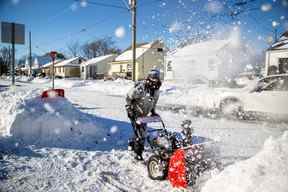 Scott Creechan utilise un chasse-neige pour dégager son entrée à Fort Erie, en Ontario, le 20 novembre 2022