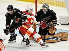 L'attaquant des Flames de Calgary Andrew Mangiapane affronte le défenseur des Capitals de Washington Nick Jensen et le gardien de but Darcy Kuemper au Capital One Arena de Washington le vendredi 25 novembre 2022.