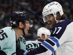 Andre Burakovsky du Kraken et Adam Lowry des Jets de Winnipeg se sont battus au Climate Pledge Arena de Seattle, Washington, dimanche soir.  Getty Images