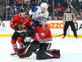 L'attaquant des Jets Saku Maenalanen (8), le défenseur des Blackhawks de Chicago Caleb Jones (82) et le gardien Arvid Soderblom cherchent la rondelle lors de la victoire de 4-0 de Winnipeg au Canada Life Centre samedi.