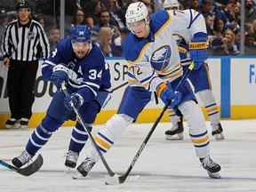 Tage Thompson des Sabres de Buffalo patine avec la rondelle contre Auston Matthews des Maple Leafs de Toronto au Scotiabank Arena le 12 avril 2022 à Toronto.