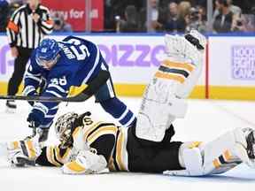 Le gardien des Bruins de Boston, Linus Ullmark, plonge pour atteindre une rondelle libre devant Michael Bunting des Maple Leafs en deuxième période au Scotiabank Arena le samedi 5 novembre 2022.