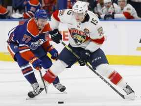 L'attaquant des Oilers d'Edmonton Connor McDavid tente d'éloigner la rondelle de l'attaquant des Panthers de la Floride Anton Lundell au cours de la deuxième période à Rogers Place.