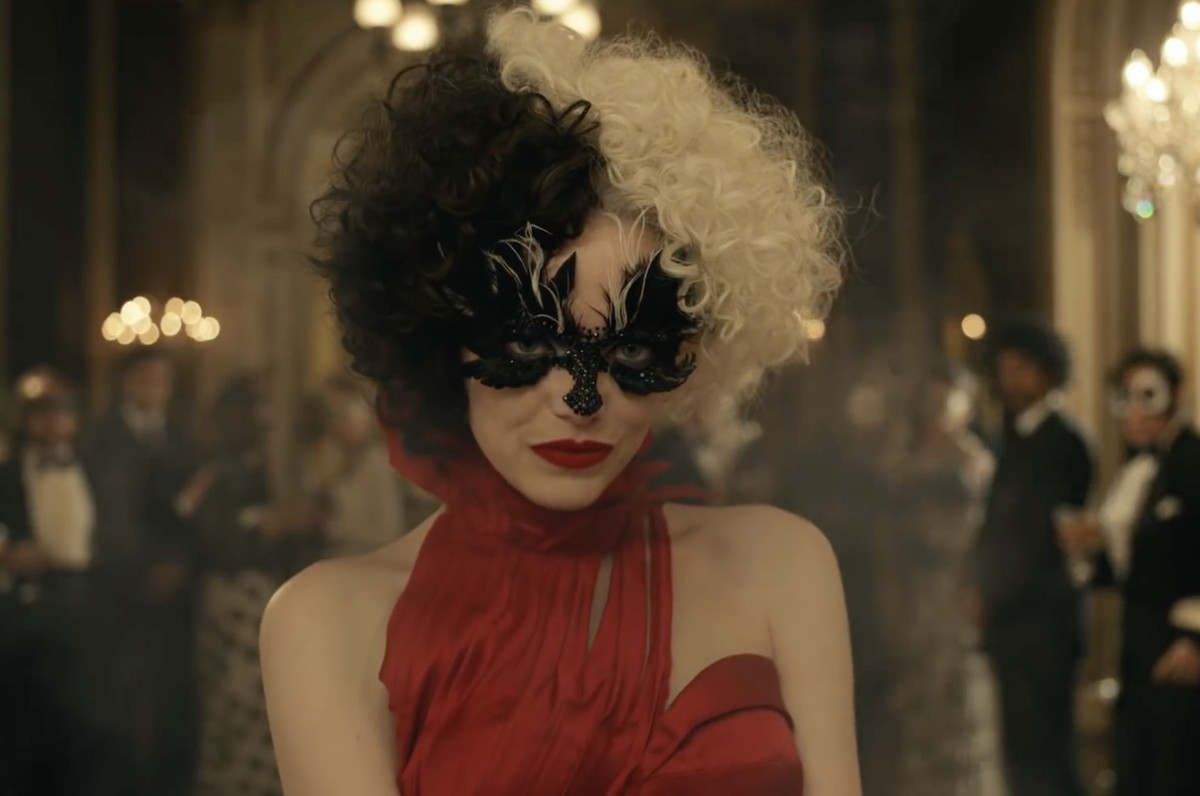 cruella de vil dans un fabuleux masque de mascarade et une robe rouge