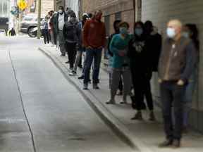 Les gens font la queue devant un centre de test COVID-19 à l'hôpital St. Michael's de Toronto.