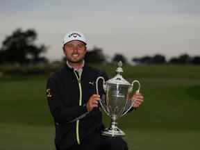 Adam Svensson, de Surrey, en Colombie-Britannique, pose avec le trophée après avoir remporté la RSM Classic au Sea Island Golf Club en Géorgie dimanche.