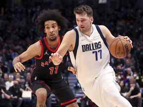 19 janvier 2022 ;  Dallas, Texas, États-Unis ;  Le gardien des Dallas Mavericks Luka Doncic (77 ans) se dirige vers le panier alors que l'attaquant des Raptors de Toronto Justin Champagnie (11 ans) défend au cours du deuxième trimestre à l'American Airlines Center.