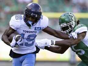 Le receveur des Argonauts de Toronto Kurleigh Gittens Jr. tente de briser le tacle du demi défensif des Roughriders de la Saskatchewan Mike Edem lors de l'action du premier quart de la LCF au stade Mosaic le dimanche 24 juillet 2022 à Regina.