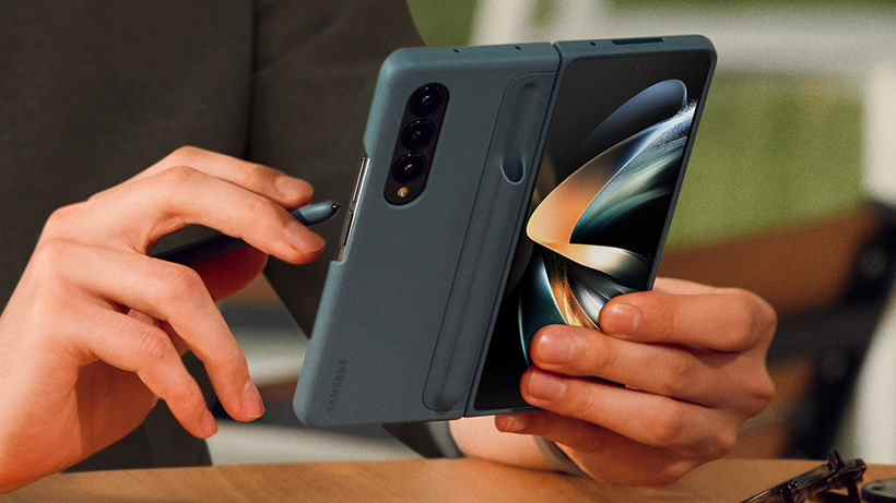 Le Samsung Galaxy Z Fold 4 dans un étui, tenu par une personne utilisant un stylet