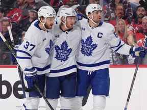 Les défenseurs des Young Leafs Timothy Liljegren (à gauche) et Rasmus Sandin (au centre) aident le capitaine John Tavares à célébrer son but en première période contre les Devils du New Jersey hier soir.