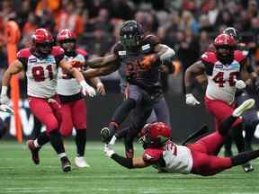 Le porteur de ballon James Butler des Lions de la Colombie-Britannique bondit sur le demi défensif des Stampeders de Calgary Branden Dozier lors de la demi-finale de la division Ouest de la LCF au BC Place à Vancouver le dimanche 6 novembre 2022.