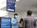 Un greeter rencontre les personnes arrivant au centre de vaccination COVID-19 du Square Décarie en 2021.