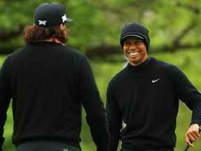 Tiger Woods (R) des États-Unis sourit avec Pat Perez (L) des États-Unis sur le vert d'entraînement lors d'une ronde d'entraînement avant le championnat PGA 2019 sur le parcours Bethpage Black le 14 mai 2019 à Bethpage, New York.