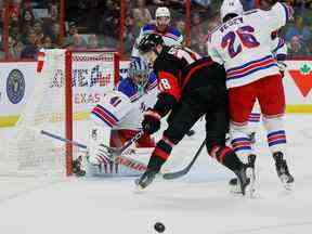 Le centre des Sénateurs d'Ottawa Tim Stützle (18) se bat pour une rondelle libre avec l'ailier gauche des Rangers de New York Jimmy Vesey (26) devant le gardien de but Jaroslav Halak (41) au cours de la première période.