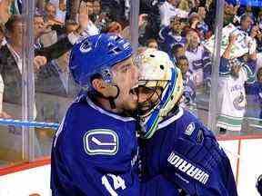 Alex Burrows célèbre avec le gardien de but Roberto Luongo après avoir remporté le trophée de la Conférence de l'Ouest après que les Canucks aient battu les Sharks de Jose en prolongation lors du cinquième match des séries éliminatoires de la Coupe Stanley au Rogers Arena.