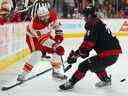 Le défenseur des Flames de Calgary Chris Tanev tire devant l'attaquant des Hurricanes de la Caroline Seth Jarvis au PNC Arena de Raleigh, en Caroline du Nord, le 26 novembre 2022. 