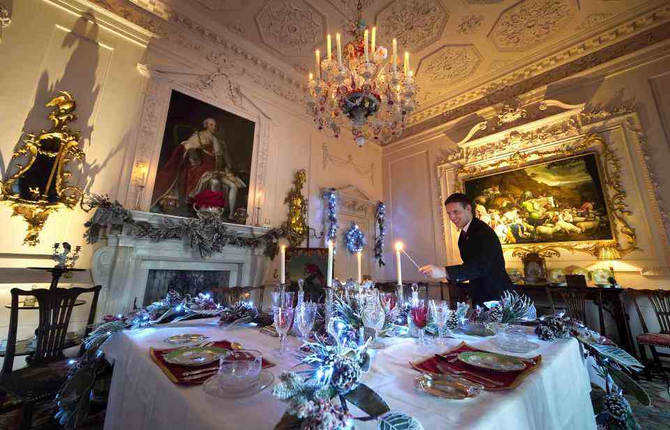 House Butler Michael Russell allume une bougie dans la salle à manger rose de Dumfries House, à Cumnock, en Écosse