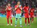 (FromL) Le milieu de terrain canadien n° 24 David Wotherspoon, le gardien de but canadien n° 16 James Pantemis et l'attaquant canadien n° 19 Alphonso Davies applaudissent les supporters après avoir perdu le match de football du groupe F de la Coupe du monde Qatar 2022 entre le Canada et le Maroc au stade Al-Thumama à Doha le 1 décembre 2022. 