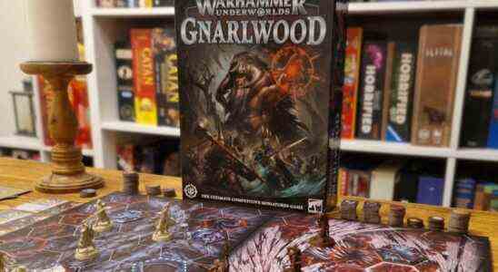 A wide shot of the Warhammer Underworlds: Gnarlwood box with the board and pieces on a wooden table