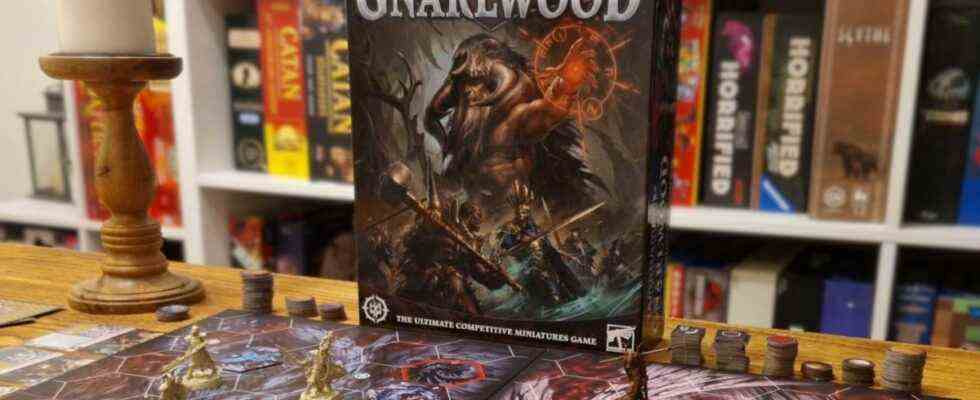 A wide shot of the Warhammer Underworlds: Gnarlwood box with the board and pieces on a wooden table