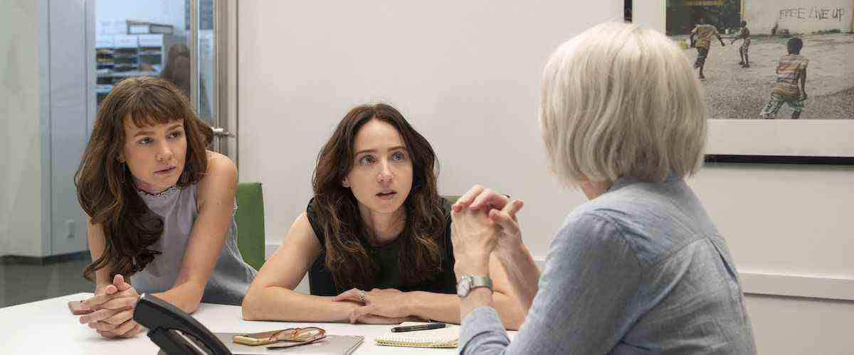 Trois femmes (Casey Mulligan, Zoe Kazan, Patricia Clarkson) sont assises attentivement l'une en face de l'autre à un bureau blanc dans un bureau décoré de photos encadrées.