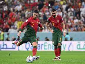 L'attaquant portugais #07 Cristiano Ronaldo (L) donne un coup de pied au milieu de terrain portugais #08 Bruno Fernandes lors des huitièmes de finale de la Coupe du monde Qatar 2022 entre le Portugal et la Suisse au stade Lusail de Lusail, au nord de Doha, le 6 décembre 2022.