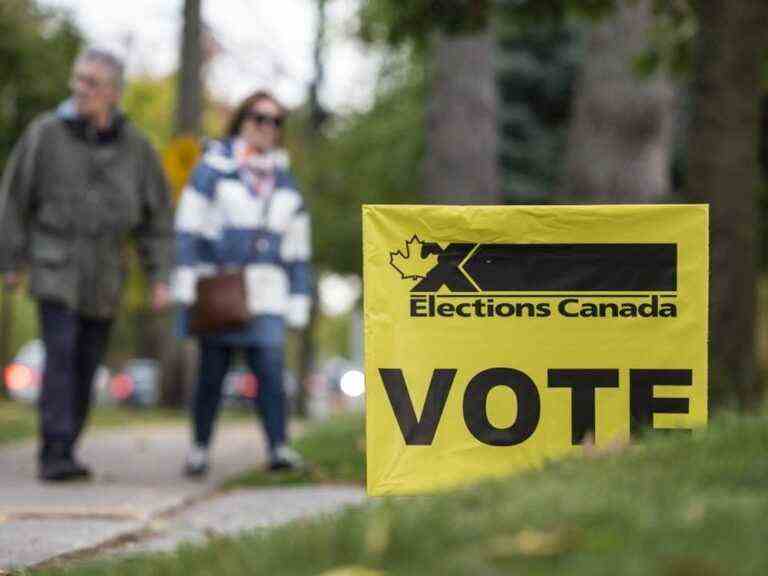 Des militants chargent un bulletin de vote lors d’une élection partielle dans la région de Toronto avec 40 candidats pour protester contre Trudeau